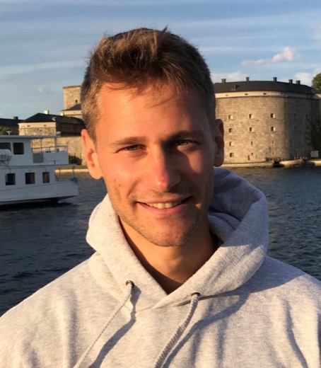 Magnus, som startade Pensionärshjälpen, står vid vattnet och ler.